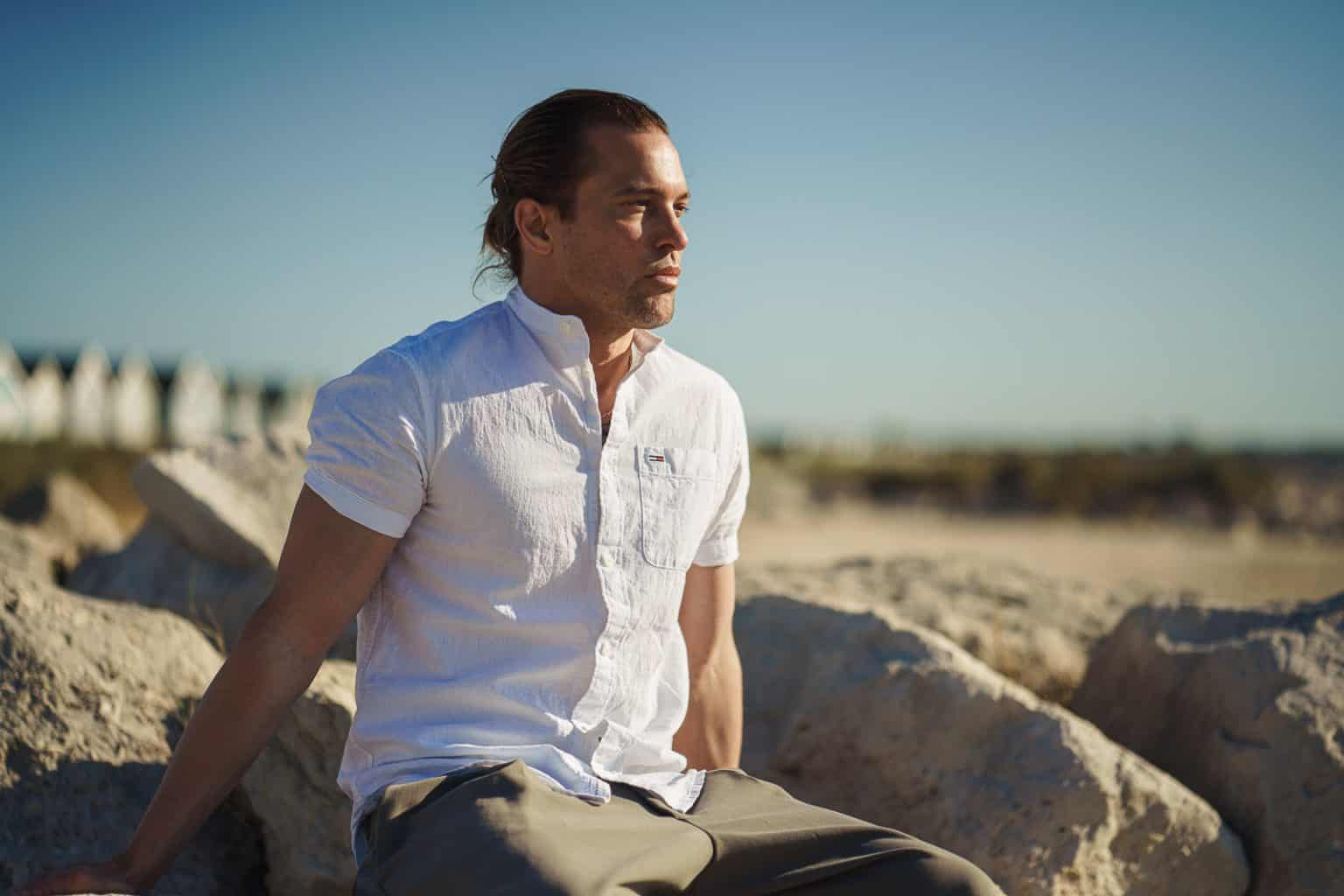 Man on relaxes on rocks at Bournemouth beach for personal branding photography